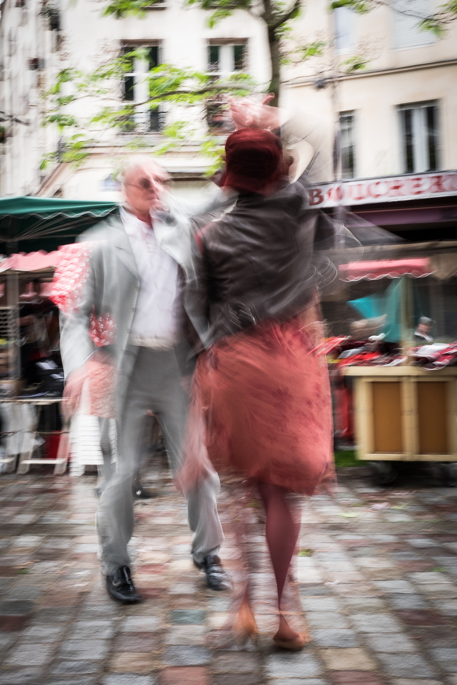 Spontaneous couple dancing to accordion music outside Saint-Médard church on Rue Mouffetard in Paris France
