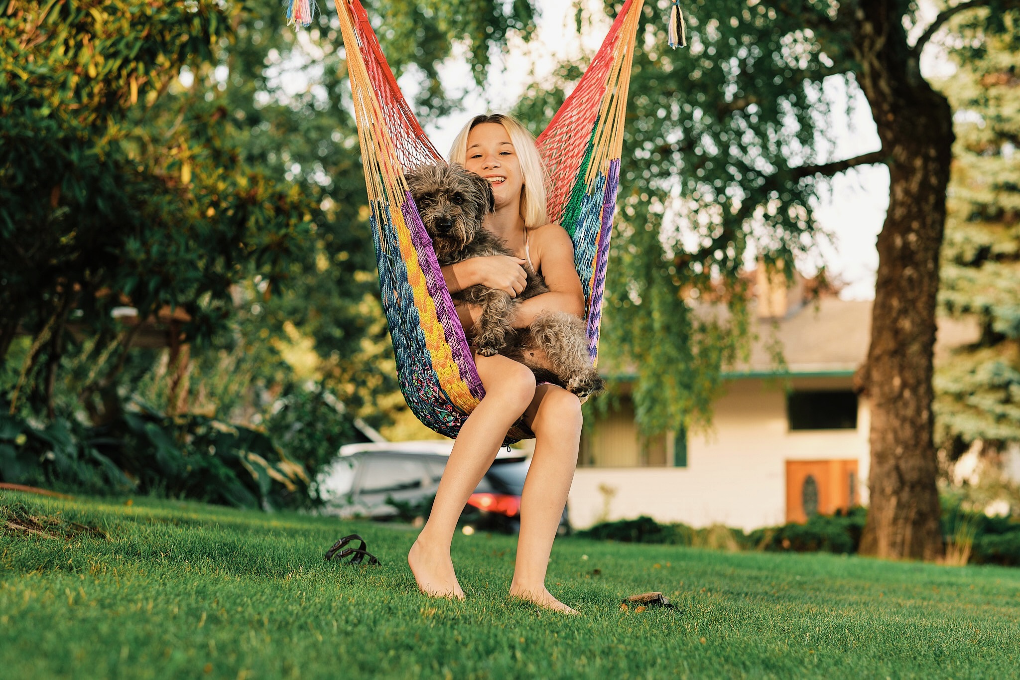 Young girl relaxing in a colorful hammock with her dog in Vancouver Washington